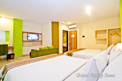 a hotel room with two beds and a tv at De Batara Hotel in Bandung