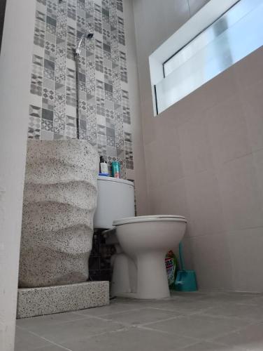 a bathroom with a toilet sitting next to a window at A-Three Guest House in Malang