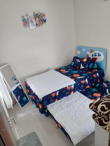 two twin beds in a room with a bedskirts at A-Three Guest House in Malang