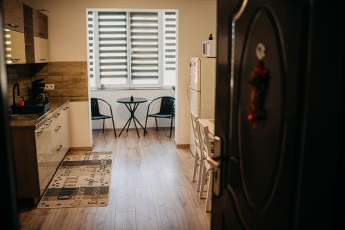 a kitchen with a refrigerator and a table with chairs at The Home in Gheorgheni