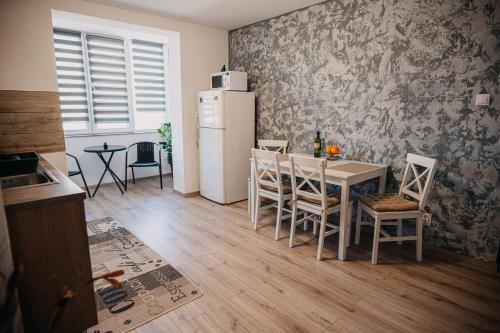 a kitchen with a table with chairs and a refrigerator at The Home in Gheorgheni