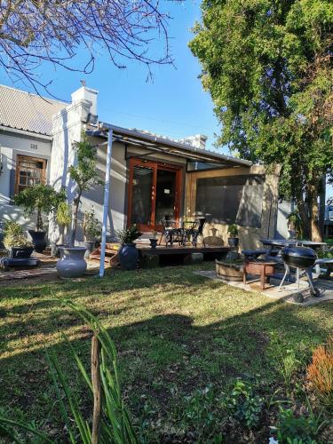 a backyard with a patio and a house at De Oude Schuur in Stellenbosch