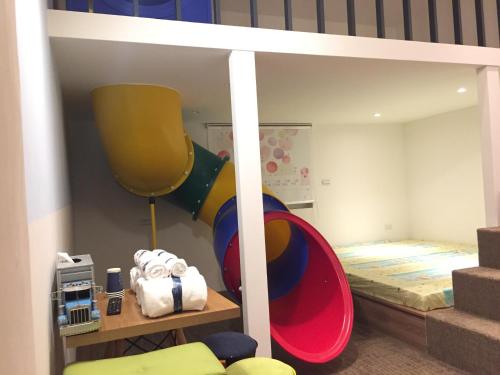 ein Kinderschlafzimmer mit einem Etagenbett und einer Rutsche in der Unterkunft Gathering in Kaohsiung