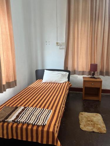 a bedroom with a bed and a table with a lamp at Floreen villa in Moratuwa