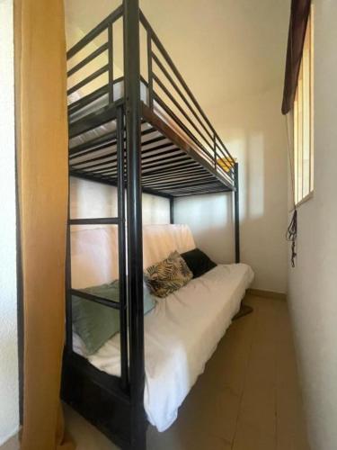 a bunk bed with a cat sitting on the bottom bunk at Studio cabine, vue mer, piscine in Saint-Cyprien-Plage