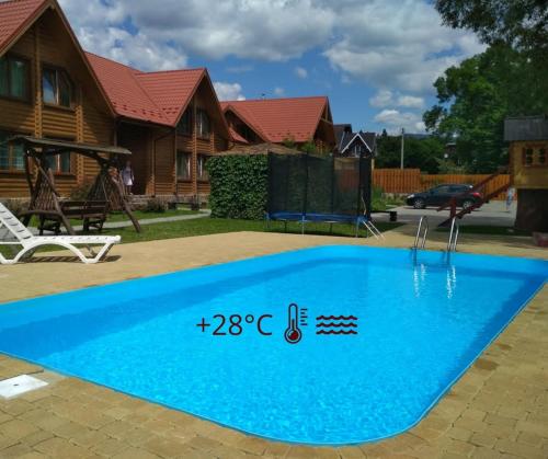 a blue swimming pool in front of a house at Mini Hotel Zakrut in Tatariv