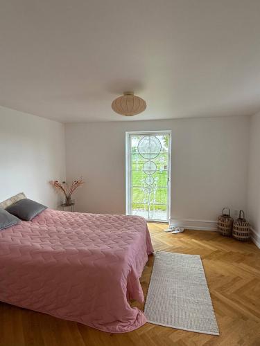 a bedroom with a pink bed and a window at Estate in calm nature in Sorø