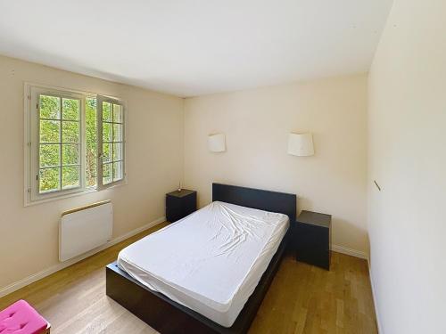 a bedroom with a bed and a window at La Villa Santranges in Châtillon-sur-Loire