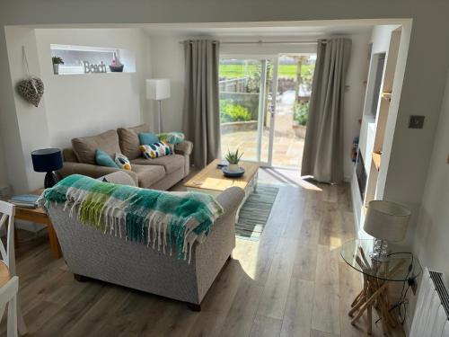a living room with a couch and a table at Lavender Cottage in Chathill