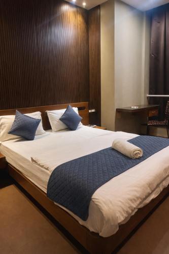 a bedroom with a large bed with blue pillows at Cassette Inn in Zahirābād