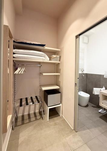 a bathroom with a closet with a sink and a toilet at B&B PREVISTO SOLE in Civitanova Marche