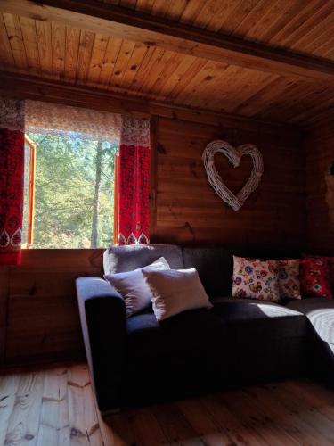a living room with a couch and a heart on the wall at Chata Koszelanka in Nadkole