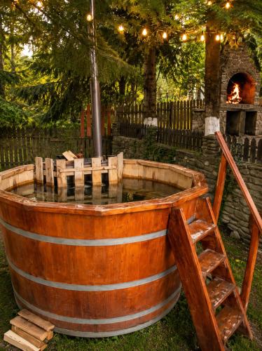 an old wooden barrel tub with a fire pit at Cabana Brazilor in Câmpina