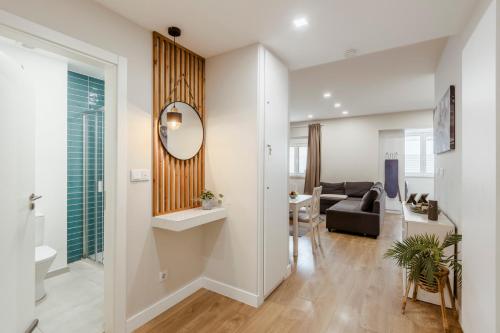 a living room with a couch and a mirror at 2-bedroom Gem Central Odivelas in Odivelas