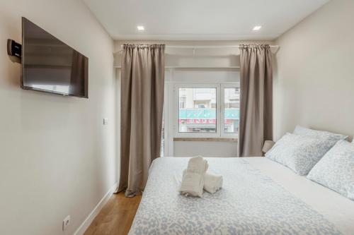a bedroom with a bed with towels on it at 2-bedroom Gem Central Odivelas in Odivelas