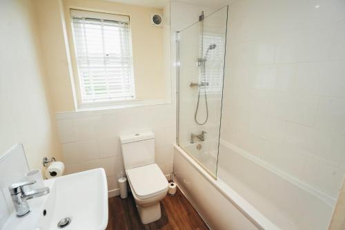 a bathroom with a shower and a toilet and a sink at Dalby House in Derby