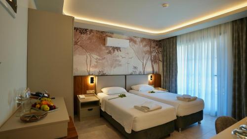 a hotel room with two beds and a desk at Ida Hotel in Marmaris