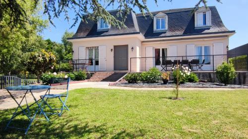 a house with a table and chairs in the yard at L'Orée des Vignes 41 - Chambres d'hôtes in Saint-Georges-sur-Cher