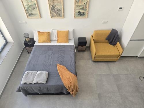 a bedroom with a bed and a yellow chair at Jardín Viveros-Turia in Valencia