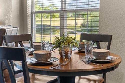 a dining room table with chairs and a wooden table with plates and glasses at Austin's Hideaway Golf-view in Branson