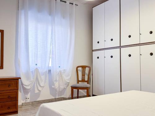 a bedroom with white cabinets and a chair and a bed at Allombra della quercia in Ortona