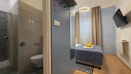 a bathroom with a toilet and a sink and a shower at Apartment & Rooms Three Angels in Baška
