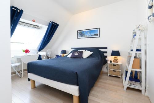 a bedroom with a blue bed and a ladder at Couette et café in Arradon