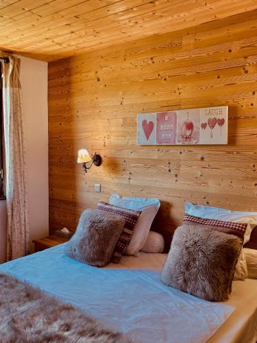 a bedroom with a bed with a wooden wall at Domaine de l'Adoux in Saint-Jean
