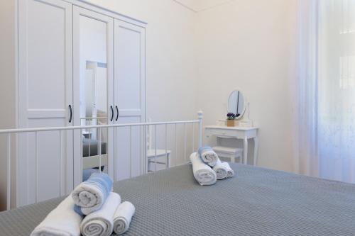 a room with a bed with towels and a mirror at Trullo Petronella in Cisternino