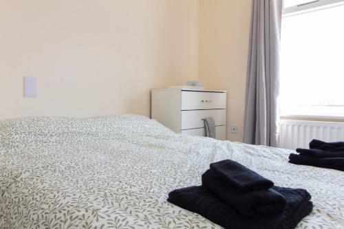 a bedroom with a bed with towels on it at Room 2 - Brookvale Guest House in Southampton