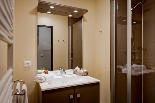 a bathroom with a sink and a large mirror at Résidence de L'Olympe in Brides-les-Bains