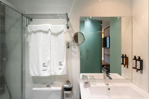 a bathroom with a sink and a toilet and a mirror at Petit Palace Alcalá in Madrid