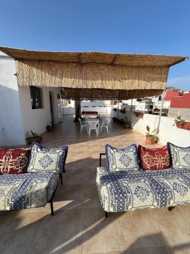 a patio with two couches and a table on a roof at Atlantic view Tamraght 2 in Tamraght Ou Fella