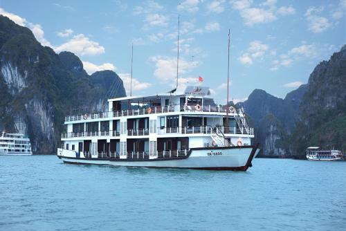 a boat on the water with mountains in the background at Mila Lux Cruises in Ha Long