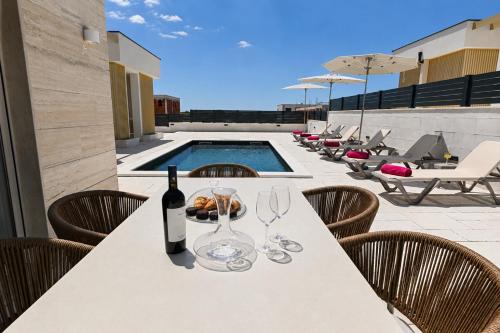 a table with a bottle of wine and wine glasses at Villa Stone in Smoković