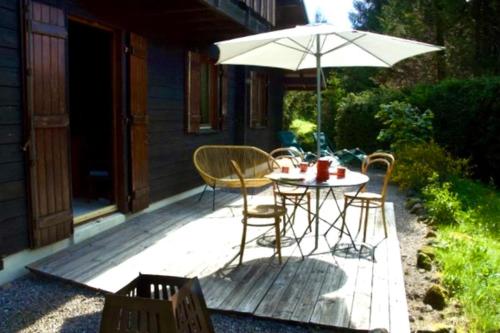 a patio with a table and chairs and an umbrella at Little Paradise hidden from view in Liézey