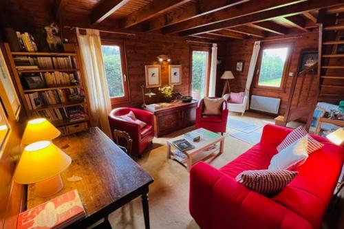 a living room with a red couch and a table at Little Paradise hidden from view in Liézey