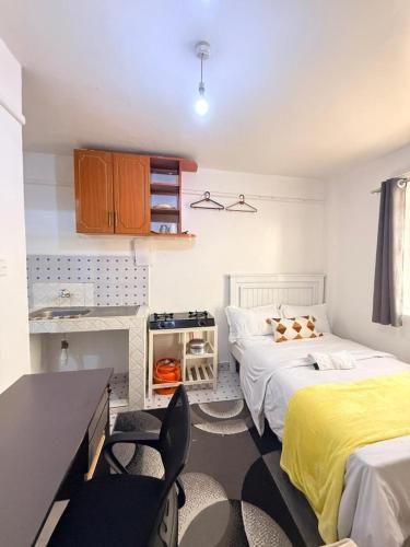 a bedroom with two beds and a desk and a table at Ruiru Cozy stays in Ruiru
