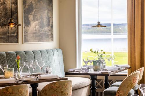 a dining room with two tables and a window at Aspenäs Herrgård in Lerum