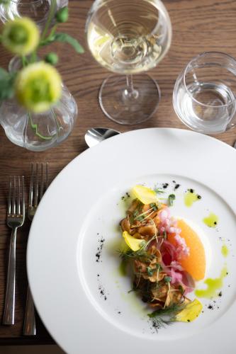 a plate of food on a table with wine glasses at Aspenäs Herrgård in Lerum