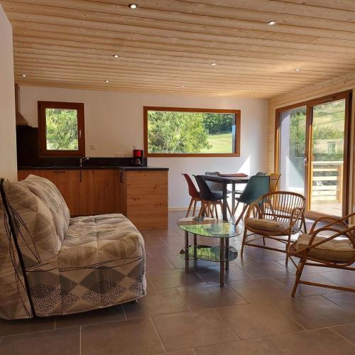 a living room with a couch and a table at Chalet Les Noisetiers in Rochesson
