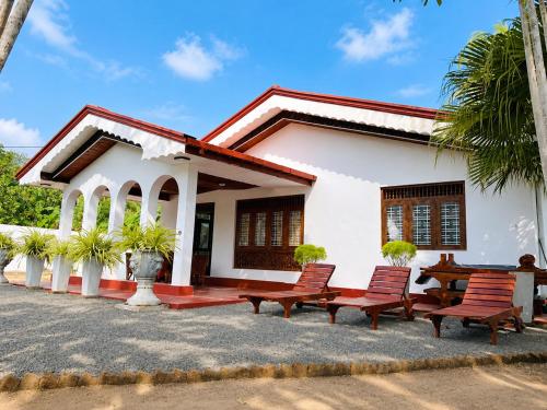 a white house with benches in front of it at Beach Star Villa Beruwala in Beruwala