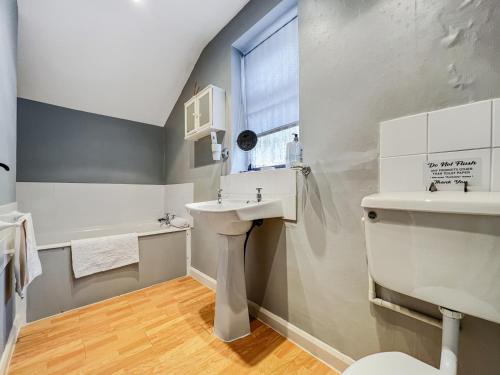 a bathroom with a sink and a toilet and a window at The Coach House Dulverton in Dulverton