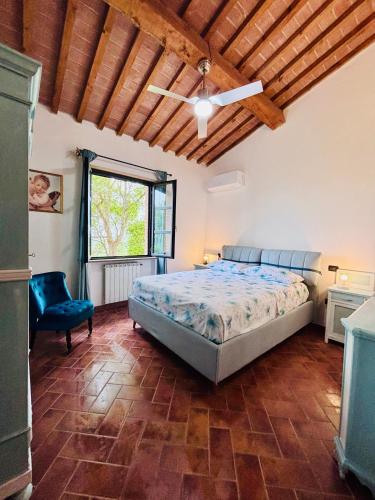 a bedroom with a bed and a blue chair at Il Casolare Val Di Mare in Riparbella