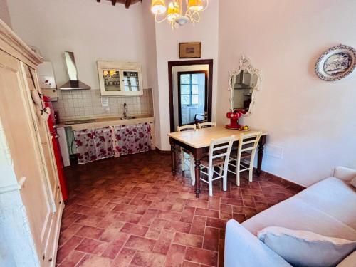 a living room with a table and a kitchen at Il Casolare Val Di Mare in Riparbella