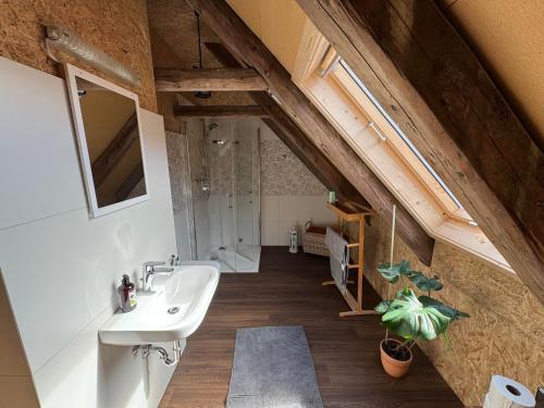 an attic bathroom with a sink and a shower at Glücksschmiede Hennersdorf in Dippoldiswalde