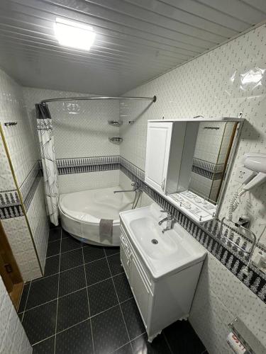a bathroom with a sink and a mirror and a tub at Nabibek boutique in Bukhara
