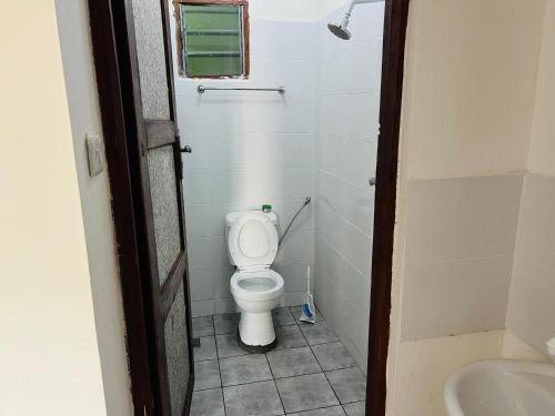 a small bathroom with a toilet and a sink at Reenhomes in Kilifi
