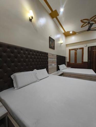 a bedroom with two beds and a headboard at Gopal Dham in Govardhan