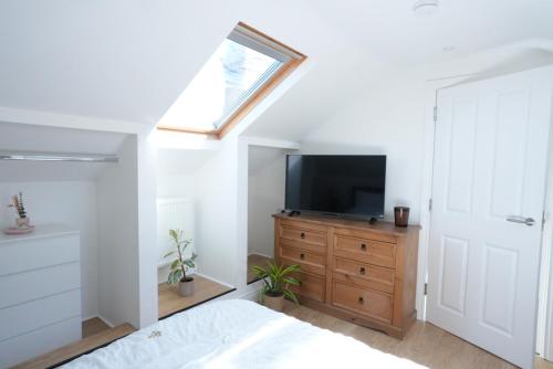 a bedroom with a bed and a television on a dresser at Steps to the Sand in Melcombe Regis